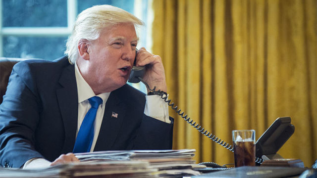 U.S. President Donald Trump speaks on the phone with Vladimir Putin, Russia's president, during the first official phone talks in the Oval Office of the White House in Washington, D.C. on Saturday, Jan. 28, 2017.(Pete Marovich/Bloomberg/Getty Images)